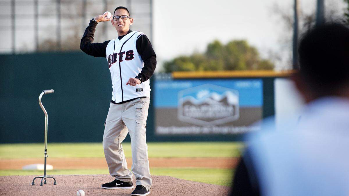 Modesto Police officer Juan Arroyo throws out the first pitch at during the Modesto Nuts home opening game at John Thurman Field in Modesto, Calif., on Thursday, April 12, 2018. Arroyo was critically injured by a suspected drunk driver while on duty in January.