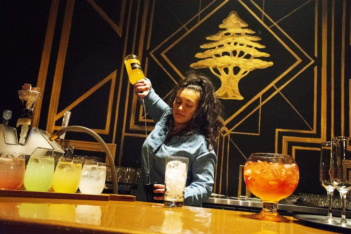 Cedar Bar & Lounge owner Chrestina Abounaoum pours a drink at the new hookah lounge and bar in downtown Modesto, Calif. Jan. 15, 2020.