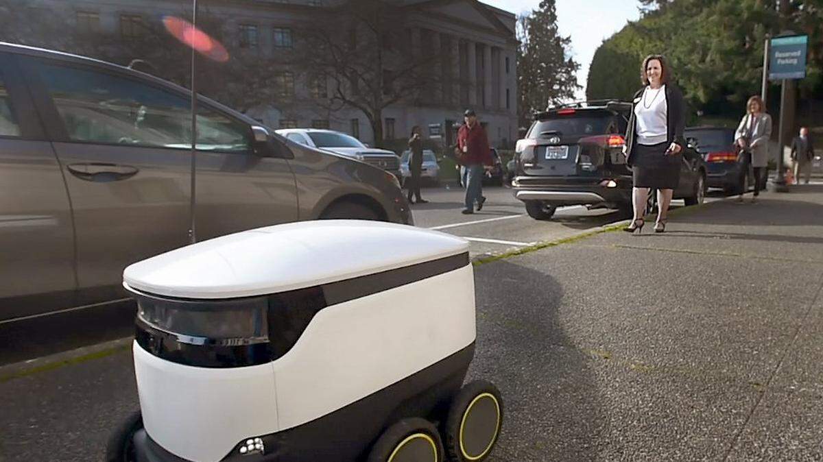 Washington State Rep. Shelly Kloba, D-1st District watches as a Self-Driving Delivery Robot built by Starship Technologies delivers a copy of House Bill1325, and which she is one of the sponsors of, to House Transportation Chair Jake Fey, who was waiting a short distance away near the south entrance to the Capitol. The Jan. 28th demonstration was in advance to the House committee’s afternoon hearing where the bill which regulates operation of “Personal Delivery Devices” was being read. Founded in 2014 with its business headquarters located in San Francisco the company’s six-wheeled, mobile robot has a working radius of about two to three miles, and is intended for use in scenarios such as company and school campus operation along sidewalk and crosswalk routes.
