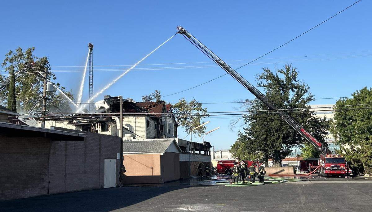 Firefighters work to extinguish the blaze at the former Franklin and Downs Funeral Homes building at 12th and G streets in downtown Modesto on Tuesday morning, July 16, 2024.