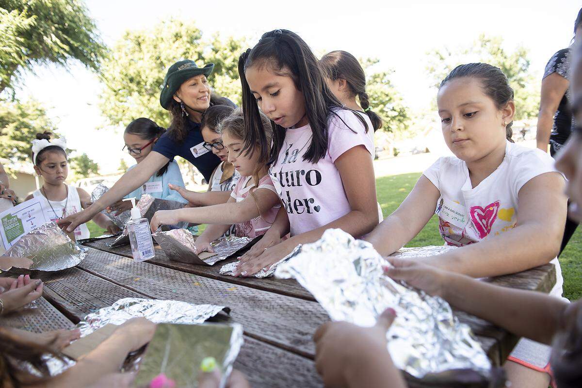 Natalia Anyna, 8, middle, and Gladis Salas-Salcedo, 8, right, and other girls participate in the Girl Scouts STEM program at the migrant farmworker housing complex in Empire, Calif., Thursday, June 6, 2019.