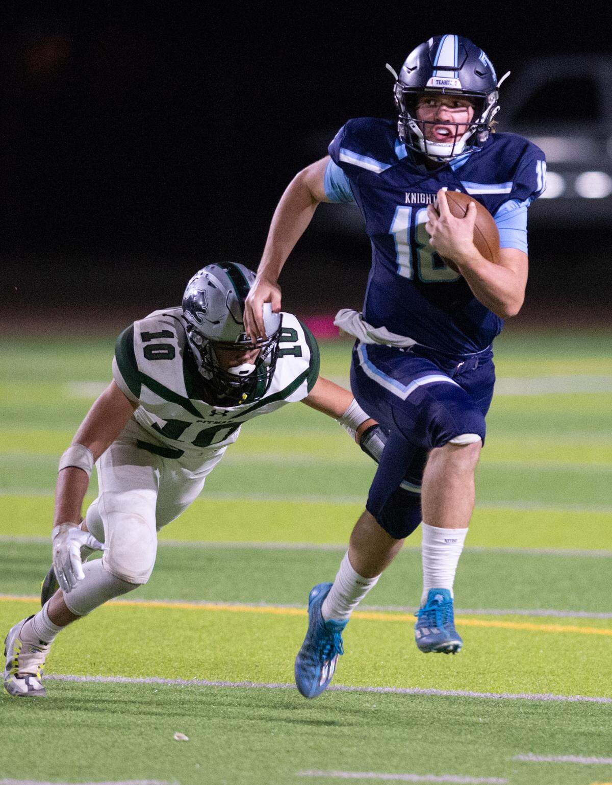 Downey quarterback Conner Stoddard eludes Pitman’s Dylan Freeman during the Central California Athletic League game at Downey High School in Modesto, Calif., Friday, Oct. 28, 2022.