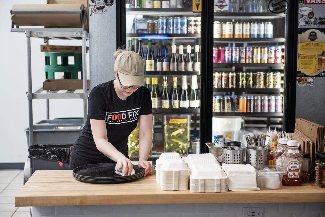 Supervisor Ali Gilbert cleans serving trays at Food Fix Butcher & Baker restaurant in Modesto, Calif., on Friday, March. 13, 2020.