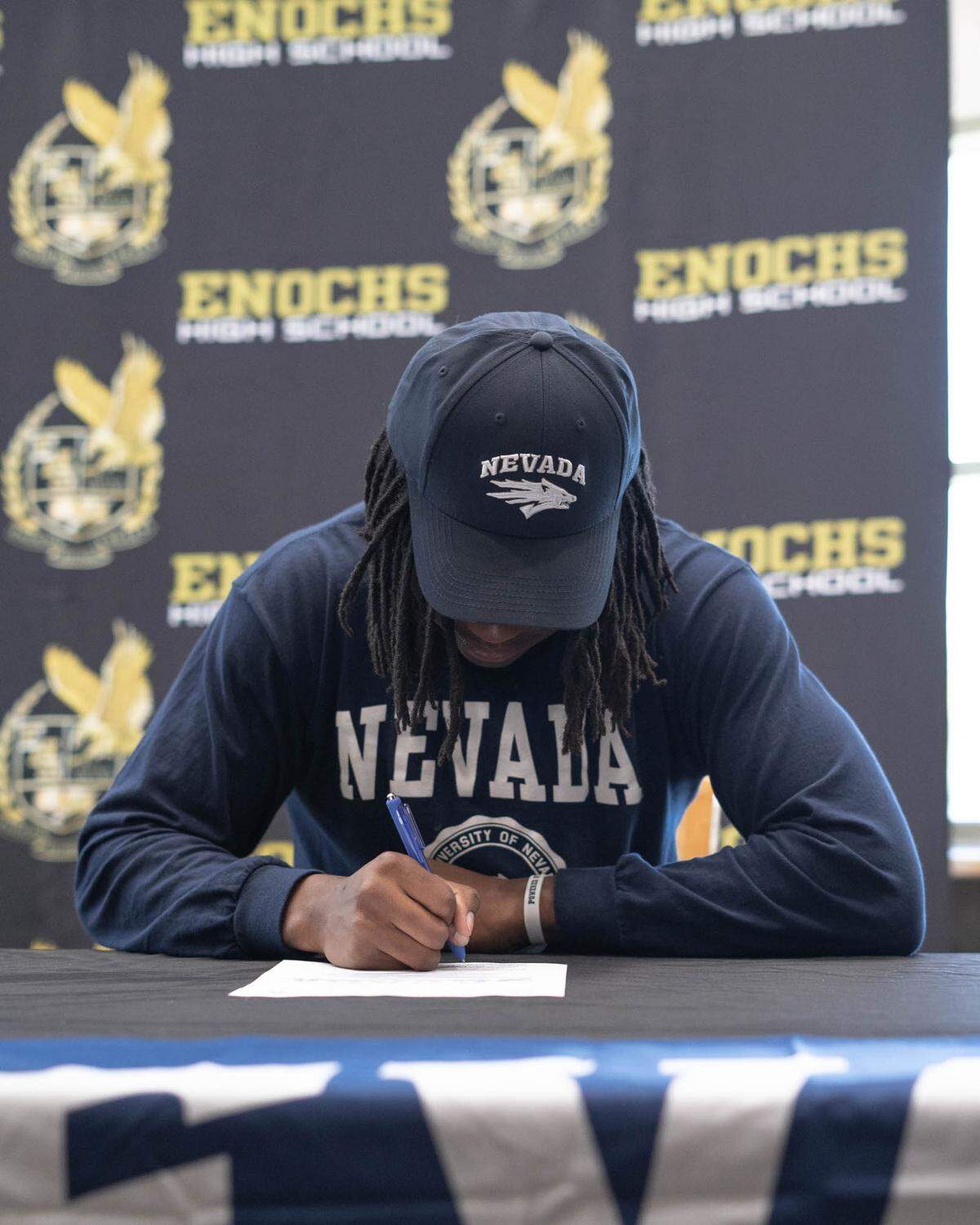 Enochs High School receiver Kola Babalola signs his letter of intent to play football at The University of Nevada, Reno at Enochs High School on Thursday, March 31, 2022.