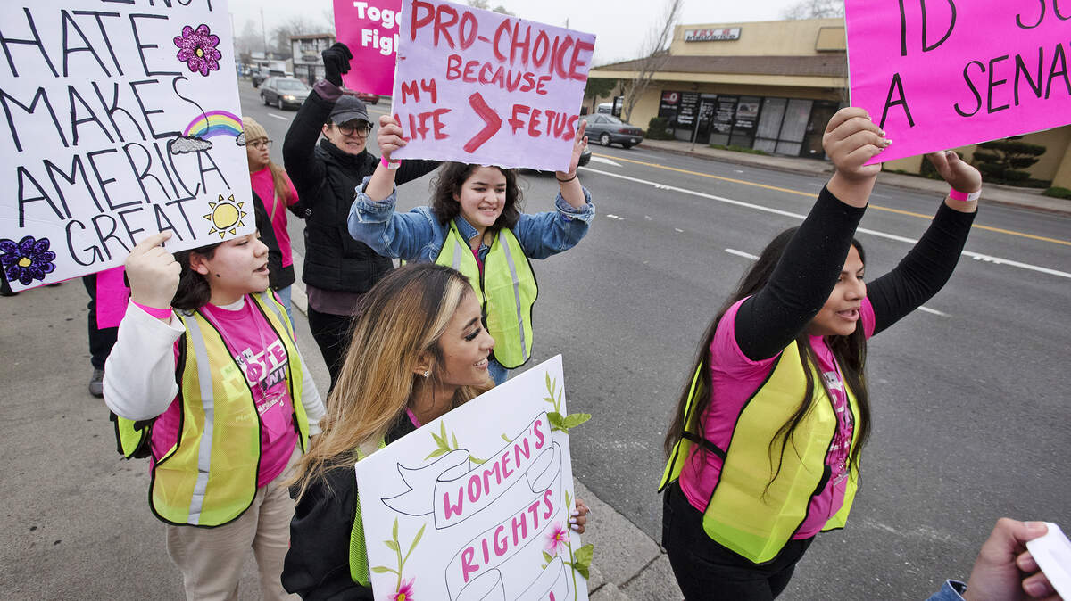 Desiree Kny, front, Yesenia Cardenas, right, Paris Casto, left, and Alexandra Castro walk along McHenry Avenue during the Women’s March Modesto in Modesto, Calif., on Saturday, Jan. 18, 2020.
