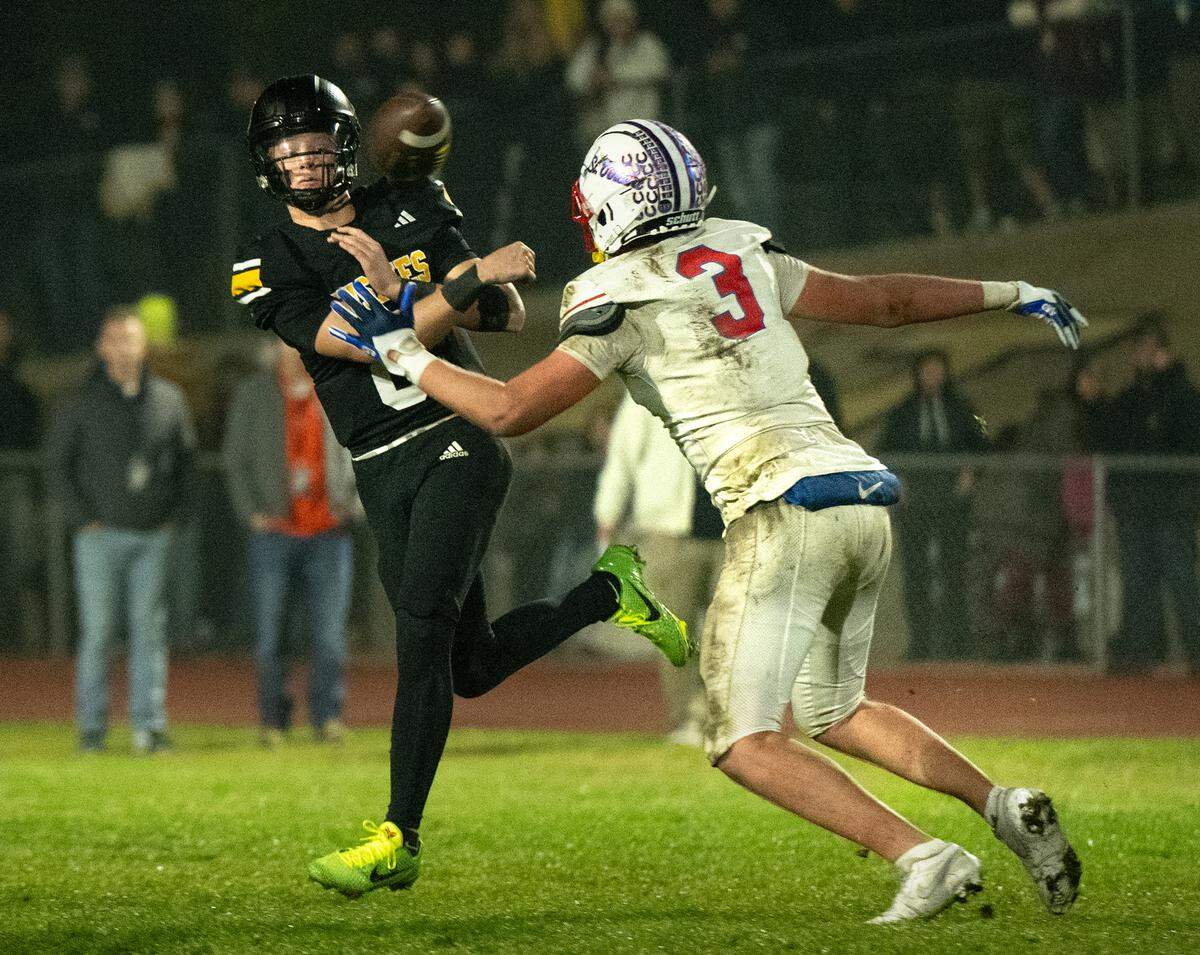Hughson quarterback Robert McDaniel unloads the ball under pressure from St. Vincent’s Jack Ellis during the CIF Northern California Division 4-AA Bowl Game in Hughson, Friday, Dec. 6, 2024.