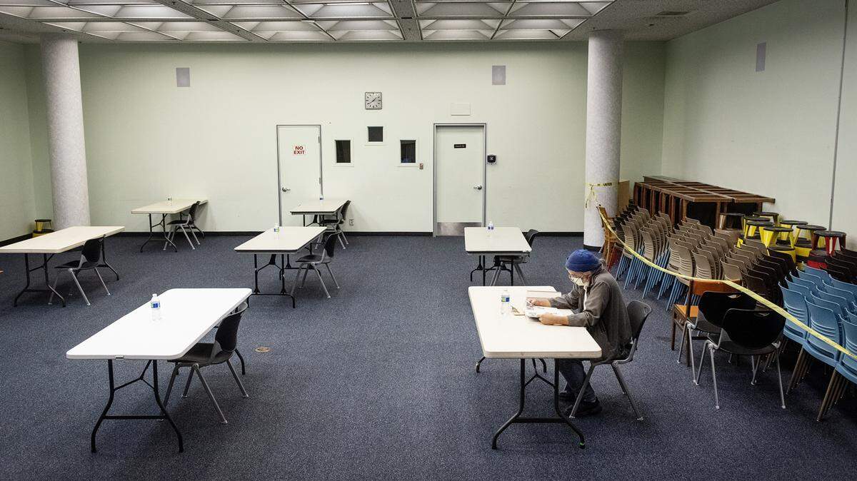 Rick Davis reads a book at the Stanislaus County cooling zone inside the Modesto Library auditorium in Modesto, Calif., on Saturday, Aug. 15, 2020.