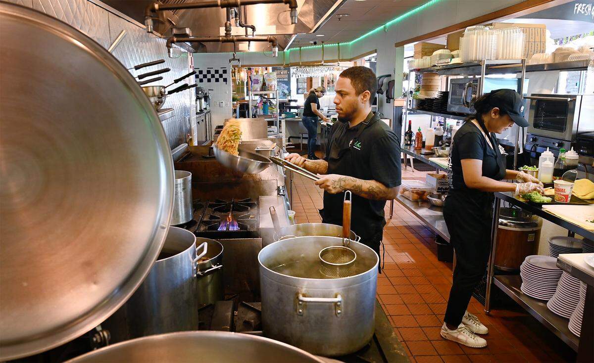 Chef Devonte Willform, left, and owner Tina Tien, right, work in the kitchen at Pho Mex restaurant in Modesto, Calif., on Thursday, June, 23, 2022.
