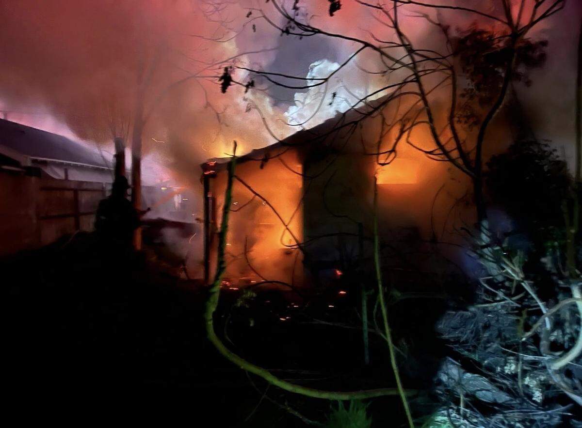 A detached structure behind a Turlock home burns as firefighters work to contain an early-morning arson fire on Wayside Drive. No injuries were reported.