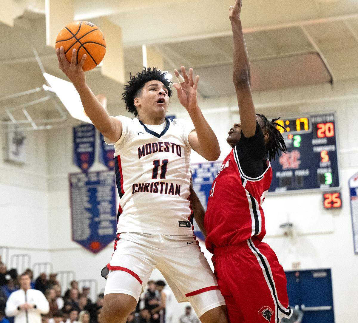 Modesto Christian’s Gavin Sykes scores over Lincoln’s Anthony Moore during the Tri-City Athletic League game at Modesto Christian High School in Salida, Calif., Friday, Jan. 12, 2024. Modesto Christian won the game 68-53.
