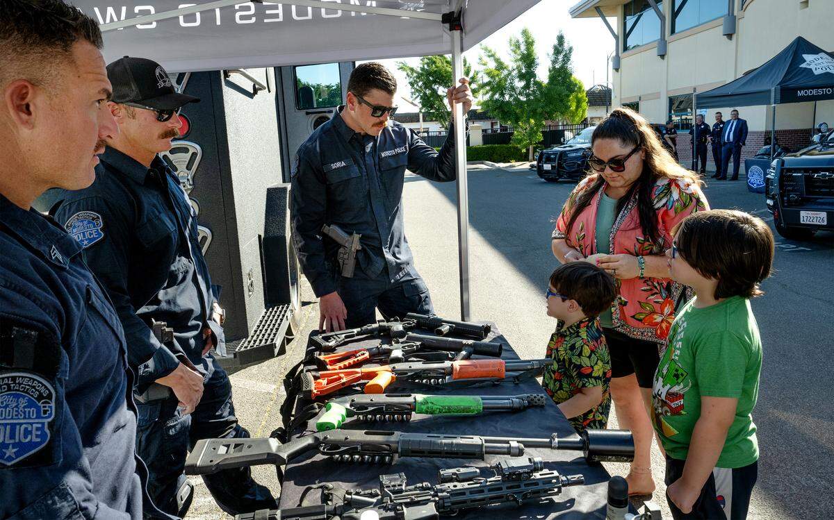 Members of the SWAT team, Jason Botsch, Jordan Panella and Brandon Soria, show some of the non-lethal firearms during an open house event at the Modesto Police Department in Modesto, Tuesday, May 19, 2026.