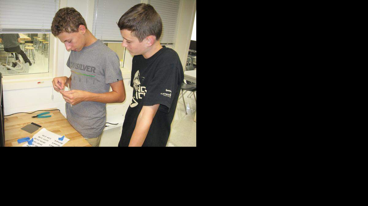 As students interested in a future in engineering, junior Bryan Ewing, left, and sophomore Harrison Hobbs work with a 3-D printer at Buhach Colony High’s Engineering Academy last week.
