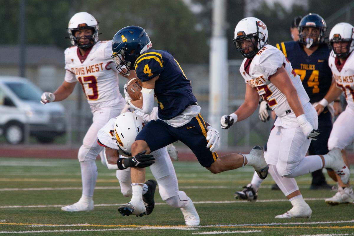 Turlock High’s Junior Silva (4) works his way upfield with the Clovis West defense closing in during the first half Friday night.
