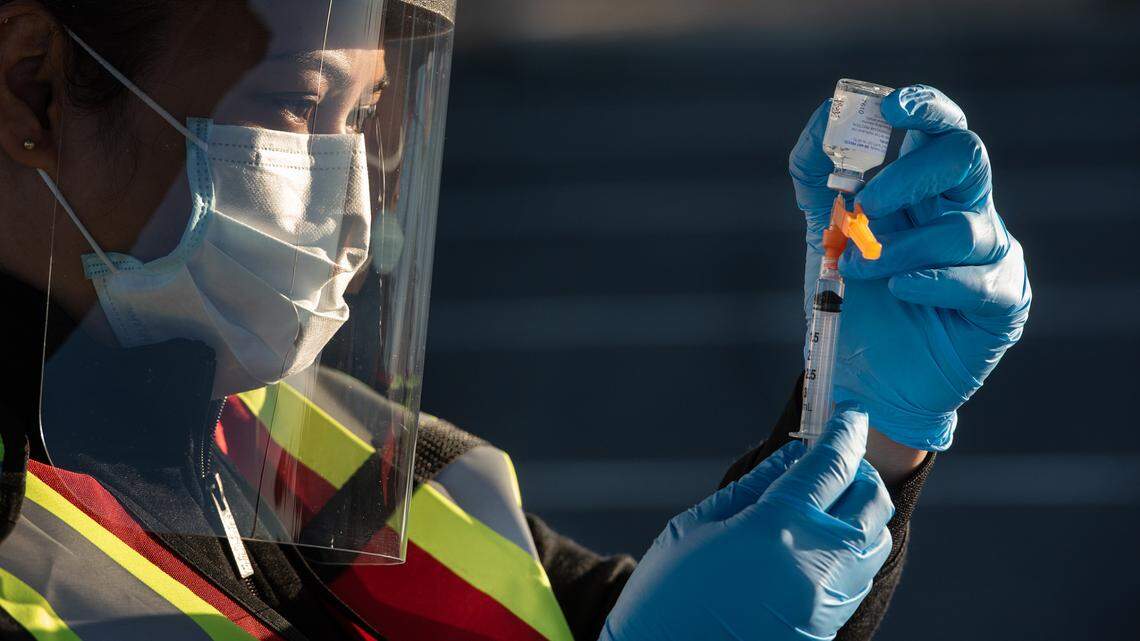 Nurse Zynda Bince prepares a flu shot as the Stanislaus County Department of Public Health conducts a drive-thru mass vaccination clinic for the flu vaccine at Johansen High School in Modesto, Calif., on Friday, Dec. 4, 2020.