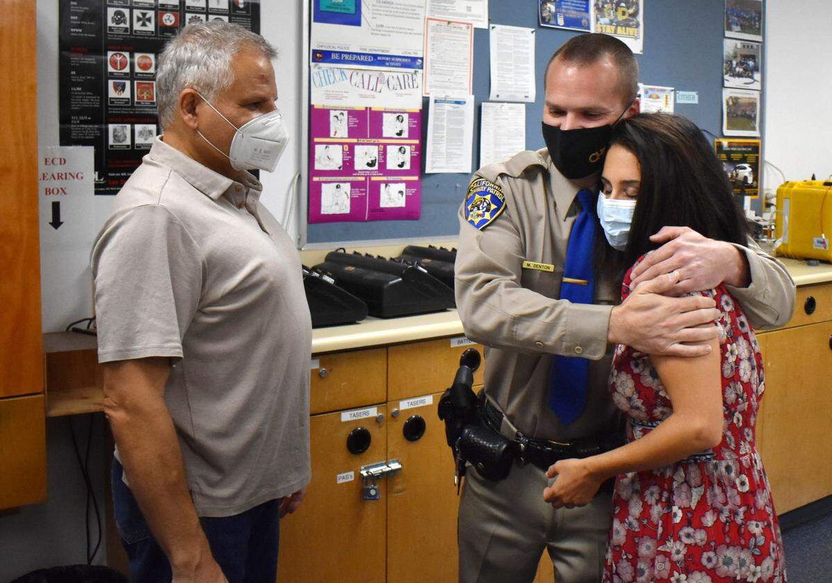 Cris Ewell hugs California Highway Patrol Officer Matt Denton, who performed CPR on her husband, Leonid Kasperovich, when he suffered a heart attack and collapsed at the Home Depot store on Carpenter Road in Modesto on Thursday, Oct. 1, 2020. They reuinited Tuesday at the CHP office on Kiernan Avenue.