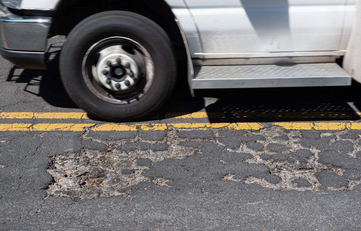 Worn and broken asphalt on Griswold Avenue in Modesto, Calif., Thursday, April 13, 2023.