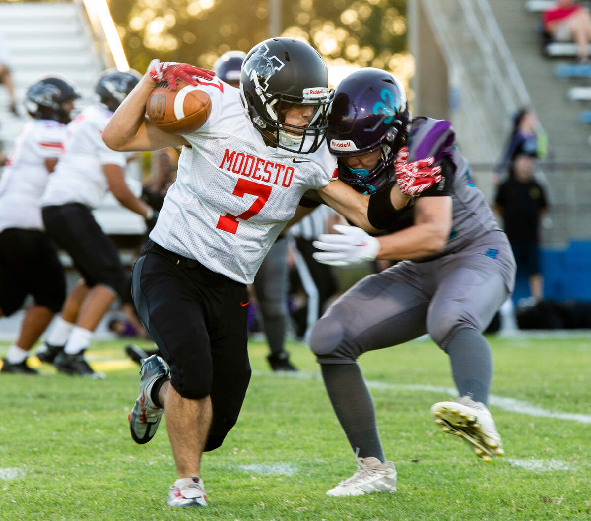 Zion Garan. 7, of Modesto High works his way up field for a few yards with Johansen holding on Friday August 19, 2022.
