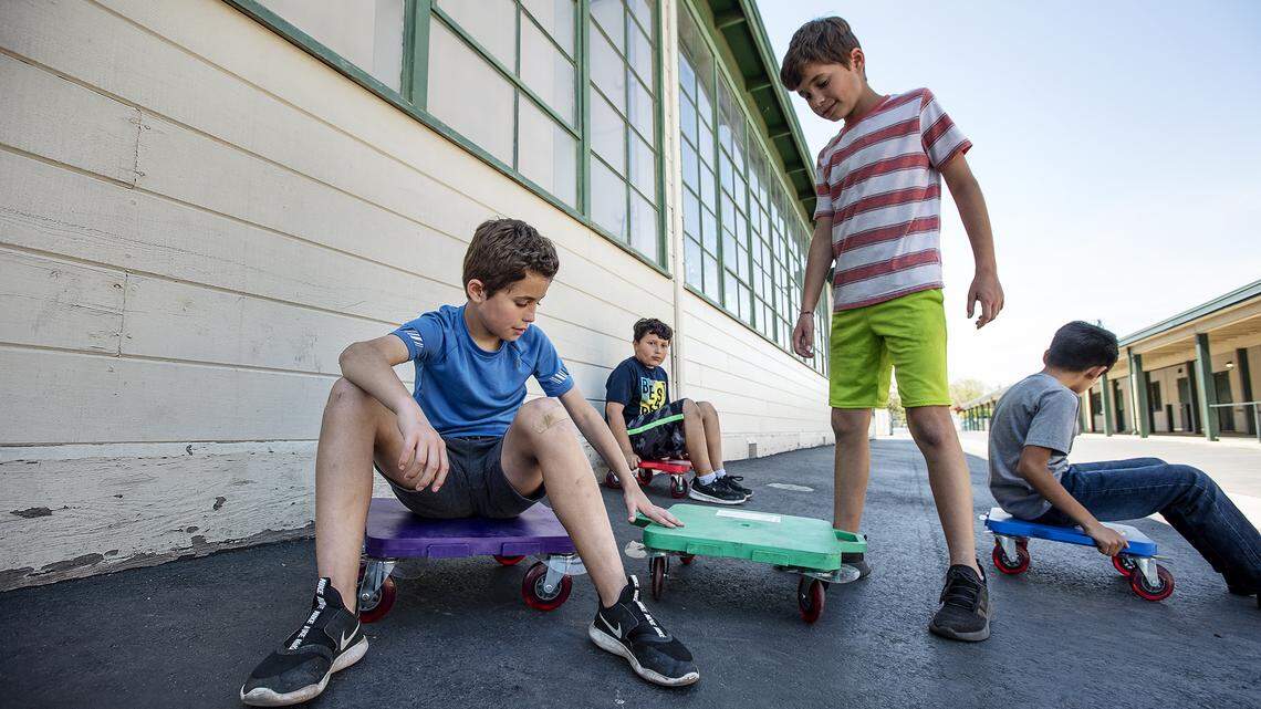 Twins Joshua and Jason Bowers, 10, play outside with Ricardo Godinez and Miguel Fararjo, right, during Modesto Schools sponsored child care program at Muir Elementary School in Modesto, Calif., on Wednesday, April 15, 2020. Modesto City Schools has been aiding health care workers, public safety first responders and its own nutrition services employees with free child care at one of its centrally located elementary campuses.