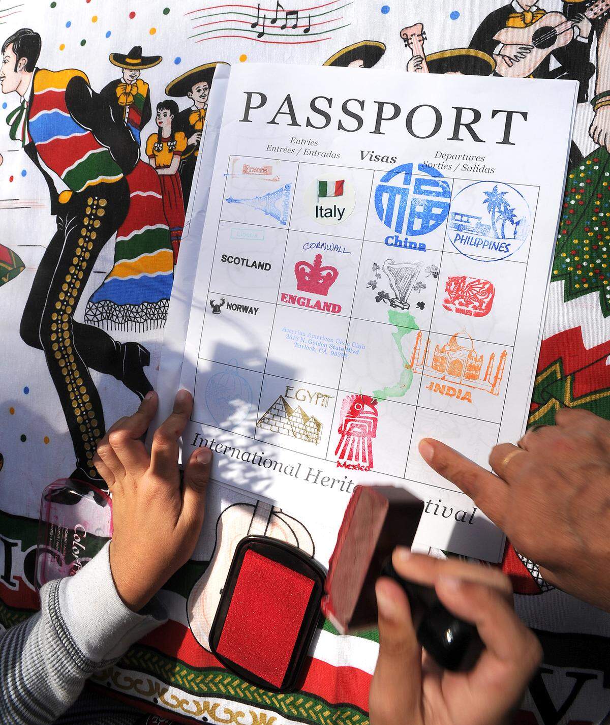 Attendees of the 22nd annual International Heritage Festival get passport stamps from the many different tents with representatives for their respective countries offering information, and traditional food and crafts.