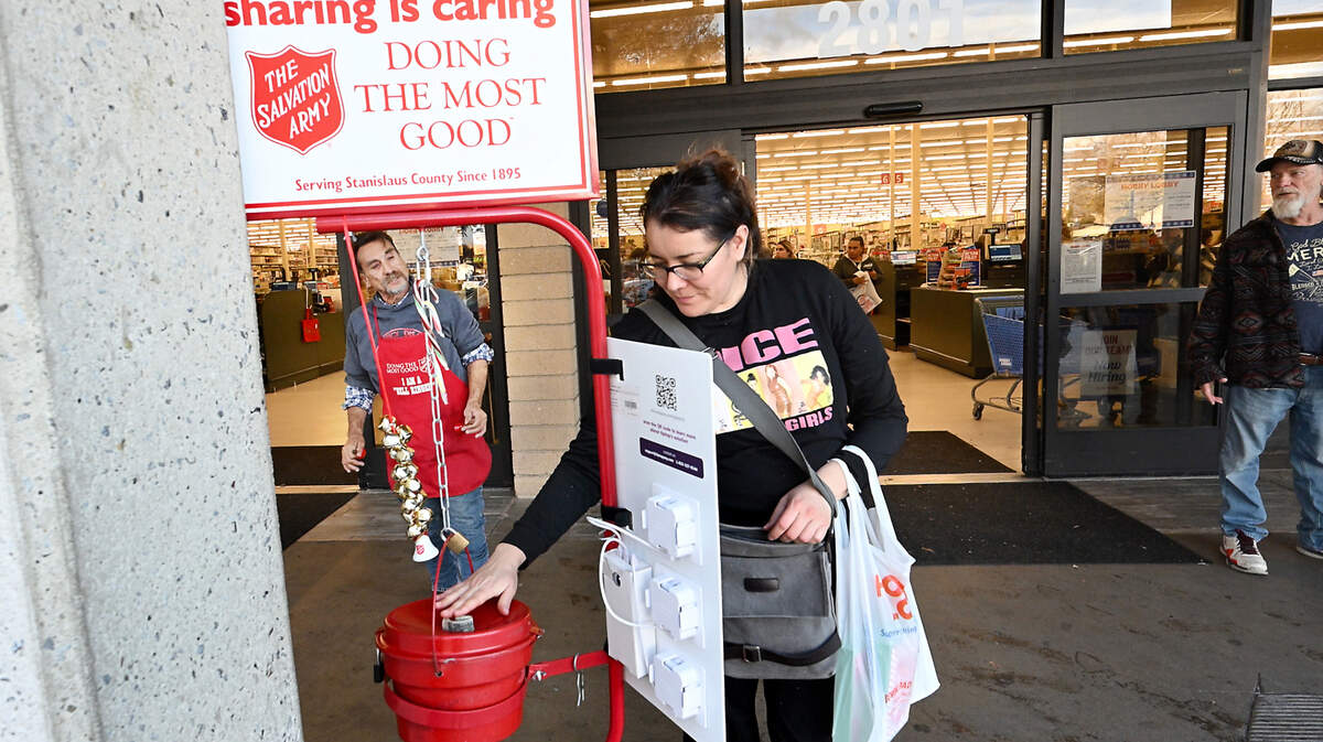 Salvation Army bell ringer Eddy Elmore, left, thanks Natalie Orndoff for her holiday donation outside Hobby Lobby in Modesto, California, Dec. 19, 2023.