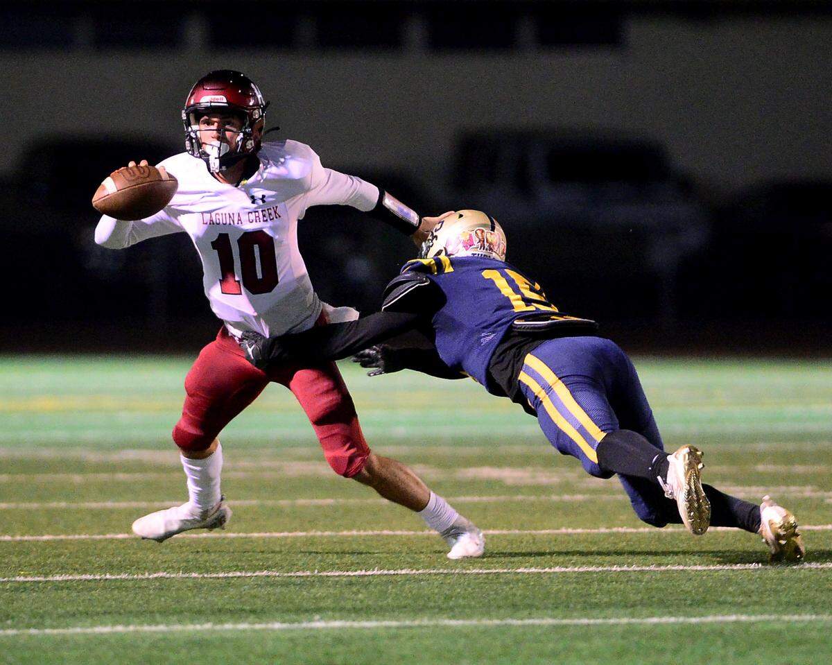 Laguna Creek quarterback Donny Cartmill (10) tries to evade Turlock’s Dominick Luna (15) during a Division 1 CIF San-Joaquin Section playoff game between Turlock High School and Laguna Creek High School at Turlock High School in Turlock California on November 8, 2024. Turlock won the game 48-12.