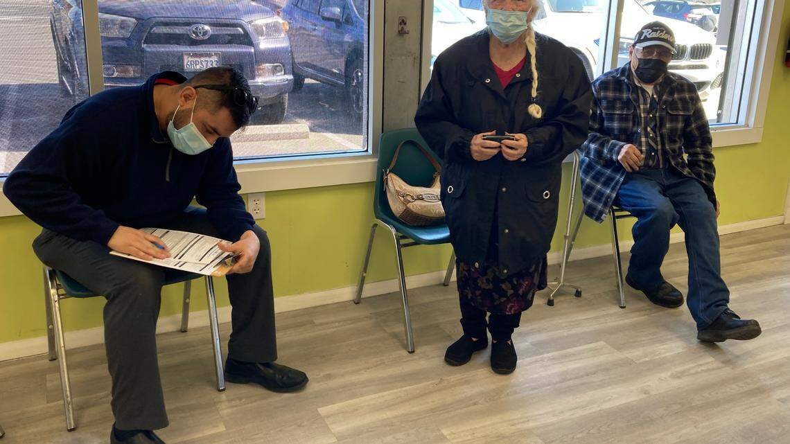Miguel Oseguera, pharmacy tech and owner of Familia Farmacia, discusses COVID-19 vaccine safety with Petra and Ascension Oviedo in south Modesto. Mar. 1, 2021