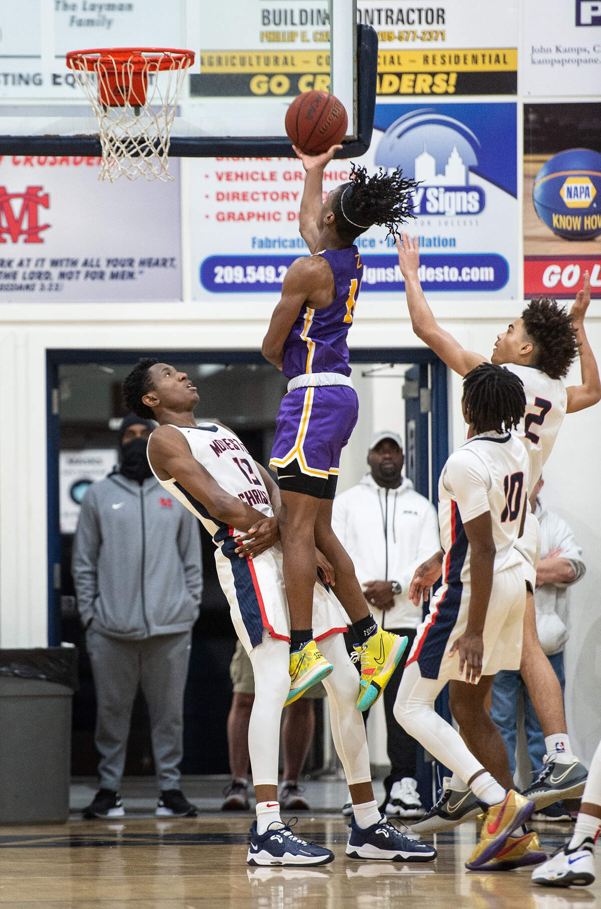 Modesto Christian’s Prince Oseya (13) takes a charge during the Holiday Hoops Classic championship game with Durango NV in Salida, Calif., on Thursday, Dec. 30, 2021.