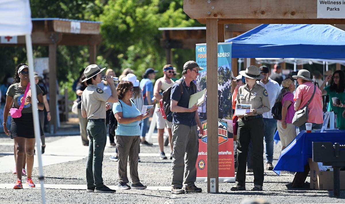 Guests talk with state park employees at Dos Rios State Park in Modesto, Calif., Wednesday June 12, 2024.