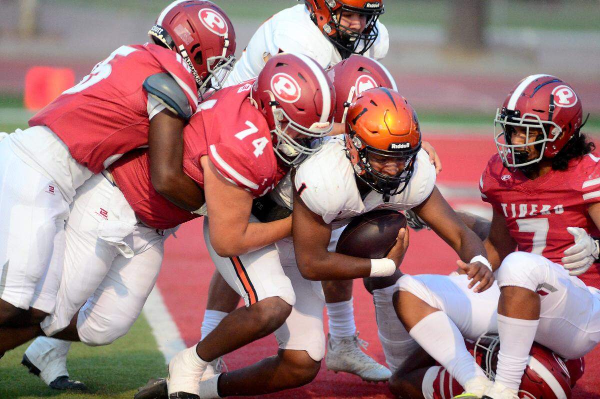 Multiple Patterson defenders sack Merced quarterback Quintell Dupree (1) during a game between Patterson High School and Merced High School at Patterson High on Aug. 23, 2024.