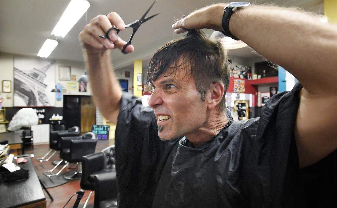 Bee photographer Andy Alfaro gives himself a haircut with the coaching of hair stylists Tiffany Rose De La Cruz and LoveCore at Tangled T’s Hair Studio in Modesto, Calif., on Friday, April 24, 2020.