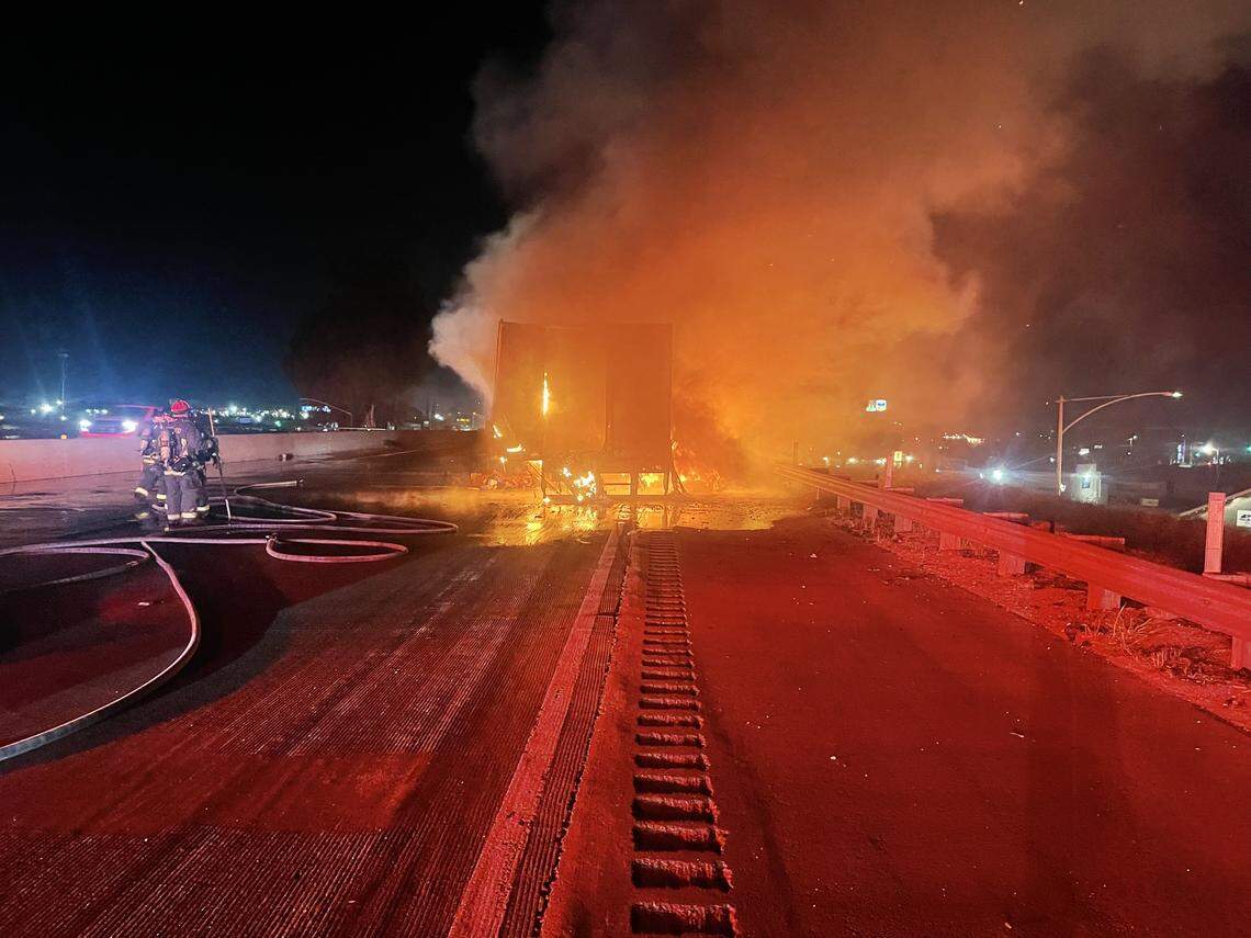 Firefighters work to contain a trailer fire on northbound Highway 99 near Ceres late Thursday night. The trailer was hauling frozen food when it caught fire after dragging along the roadway, officials said.