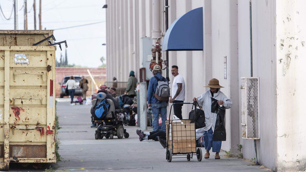 Homeless people line up outside The Salvation Army’s Berberian Shelter and Transitional Living Center in Modesto, Calif., Friday, May 17, 2019.