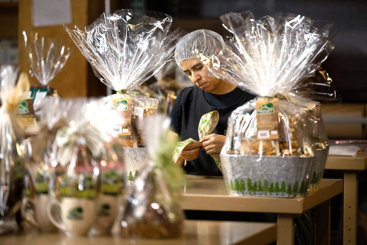 Brenda Gonzalez makes bows for gift baskets at the Stewart & Jasper Orchards company store in Newman, Wednesday, Oct. 9, 2024.