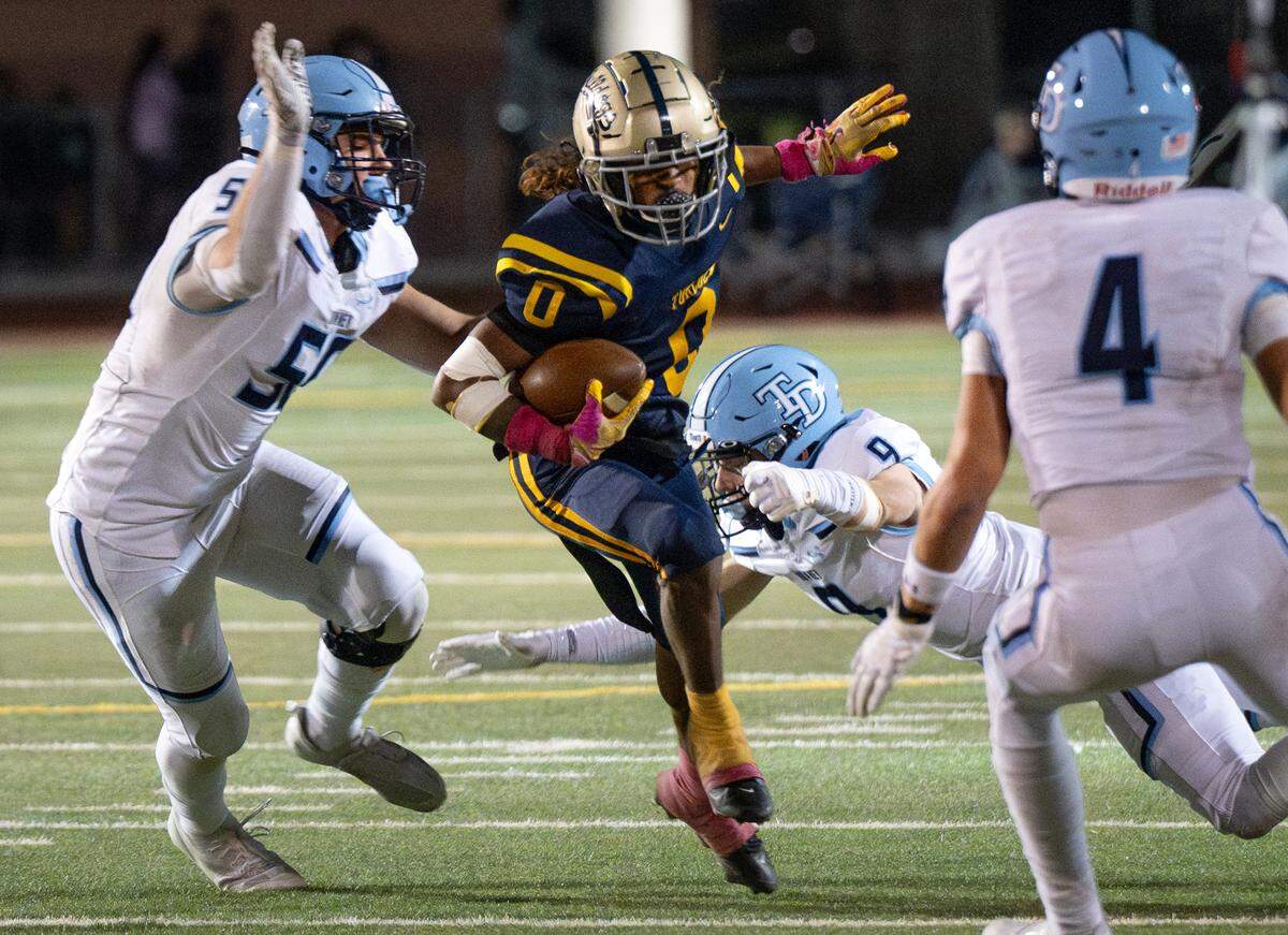 Turlock’s Jeremiah Stine runs through Downey defenders during the Central California Athletic League game at Turlock High School in Turlock, Friday, Oct. 18, 2024.