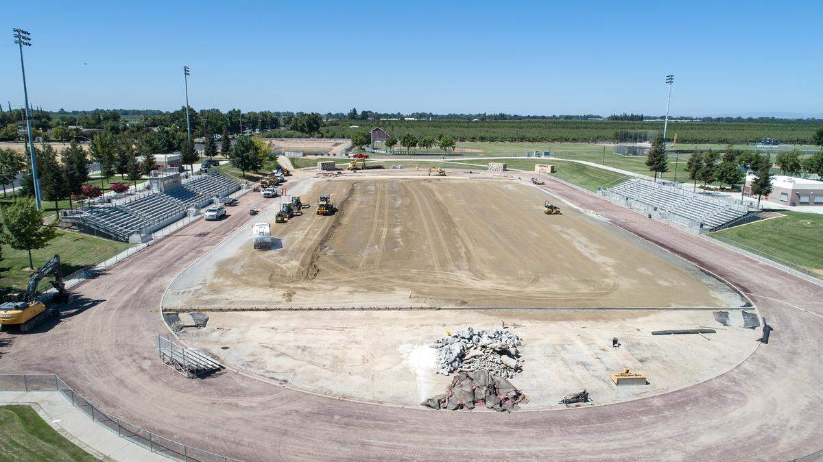 A crew prepares Gregori High School’s stadium for new artificial turf in Modesto, Calif., on Friday, July 22, 2022.
