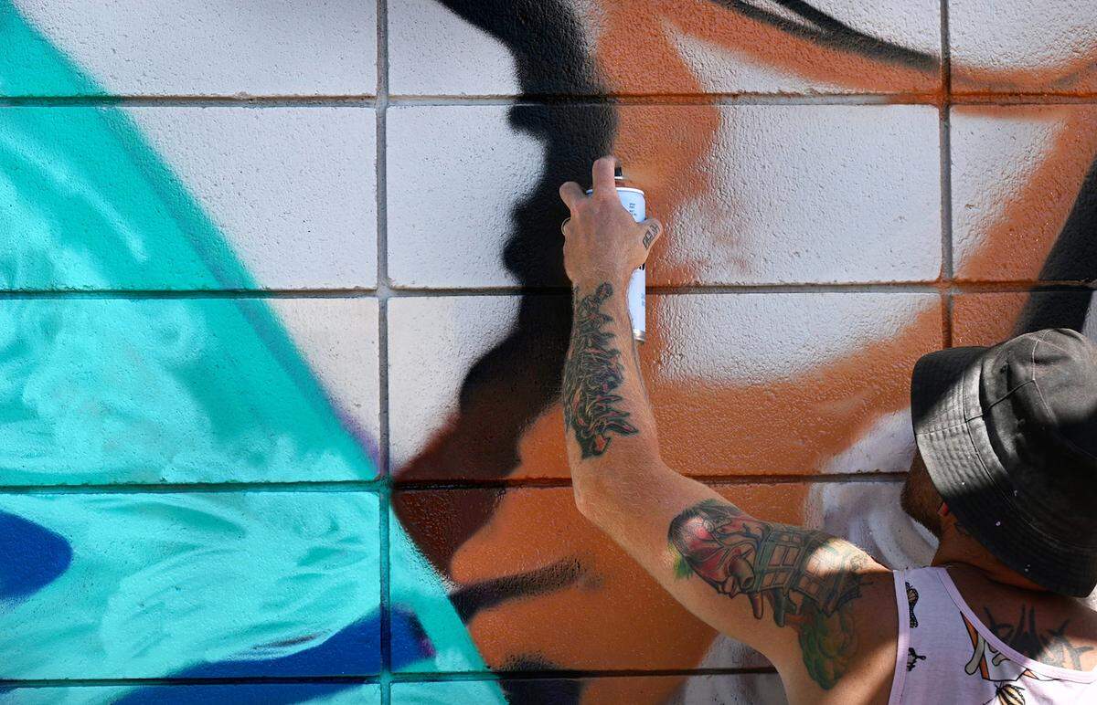 Muralist CAMER1sf works on a mural as part of the DoMo Walls Mural Festival at the Mayol & Barringer Law Offices, 1324 J St. in Modesto, Calif., on Wednesday, September 28, 2022. The festival concludes Oct. 7 during the season finale of DoMo First Fridays street fair.
