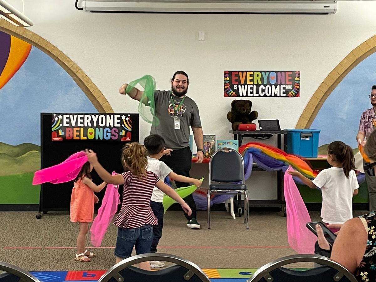 Library assistant Teddy Snyder leads children in a scarf dance during Rainbow Story Time in Salida on June 15, 2023.