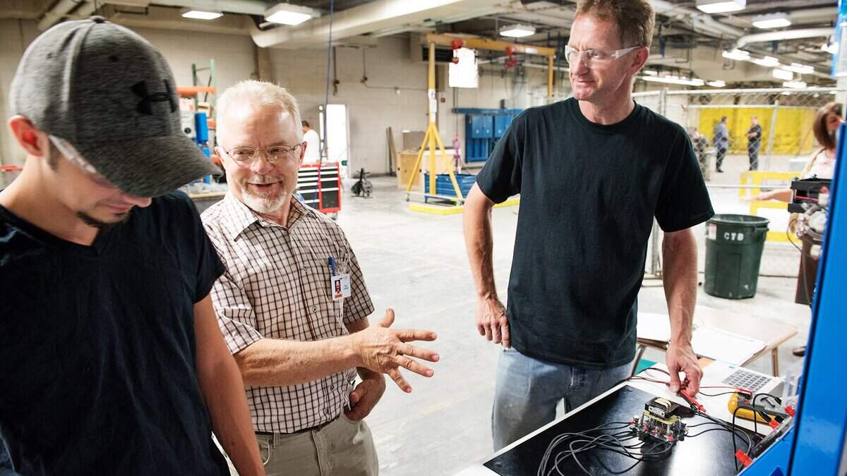 Master Trainer Ron Losinski, center, talks with students Roger Silvery, left, and Andy Inman, right, about transformers at the Volt Institute in Modesto, Calif., Thursday, June 14, 2018.