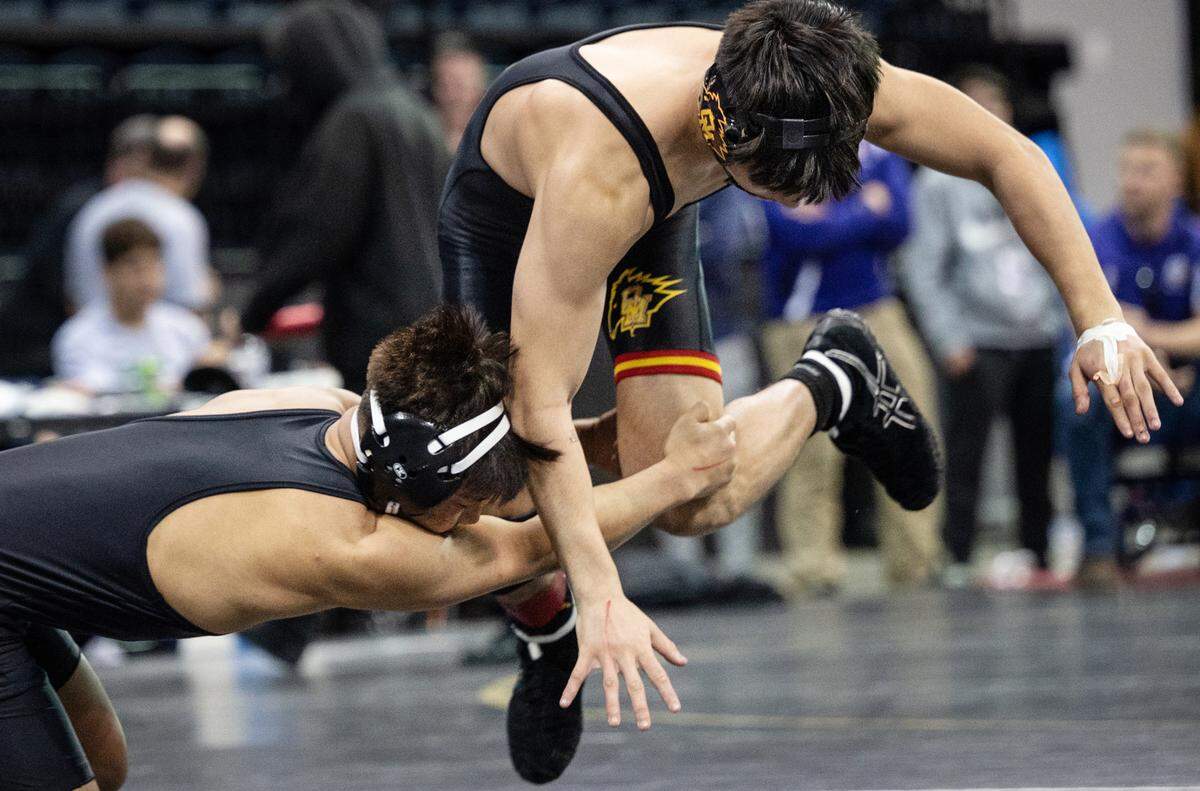 Eric Almarinez of Vacaville tries to grab a jumping Jonathan Hernandez of Oakdale in the 138-pound championship match during the CIF Sac-Joaquin Section Masters Wrestling Tournament at the Stockton Arena in Stockton, Calif., on Saturday, Feb. 19, 2022. Almarinez won 5-0 for fist place.