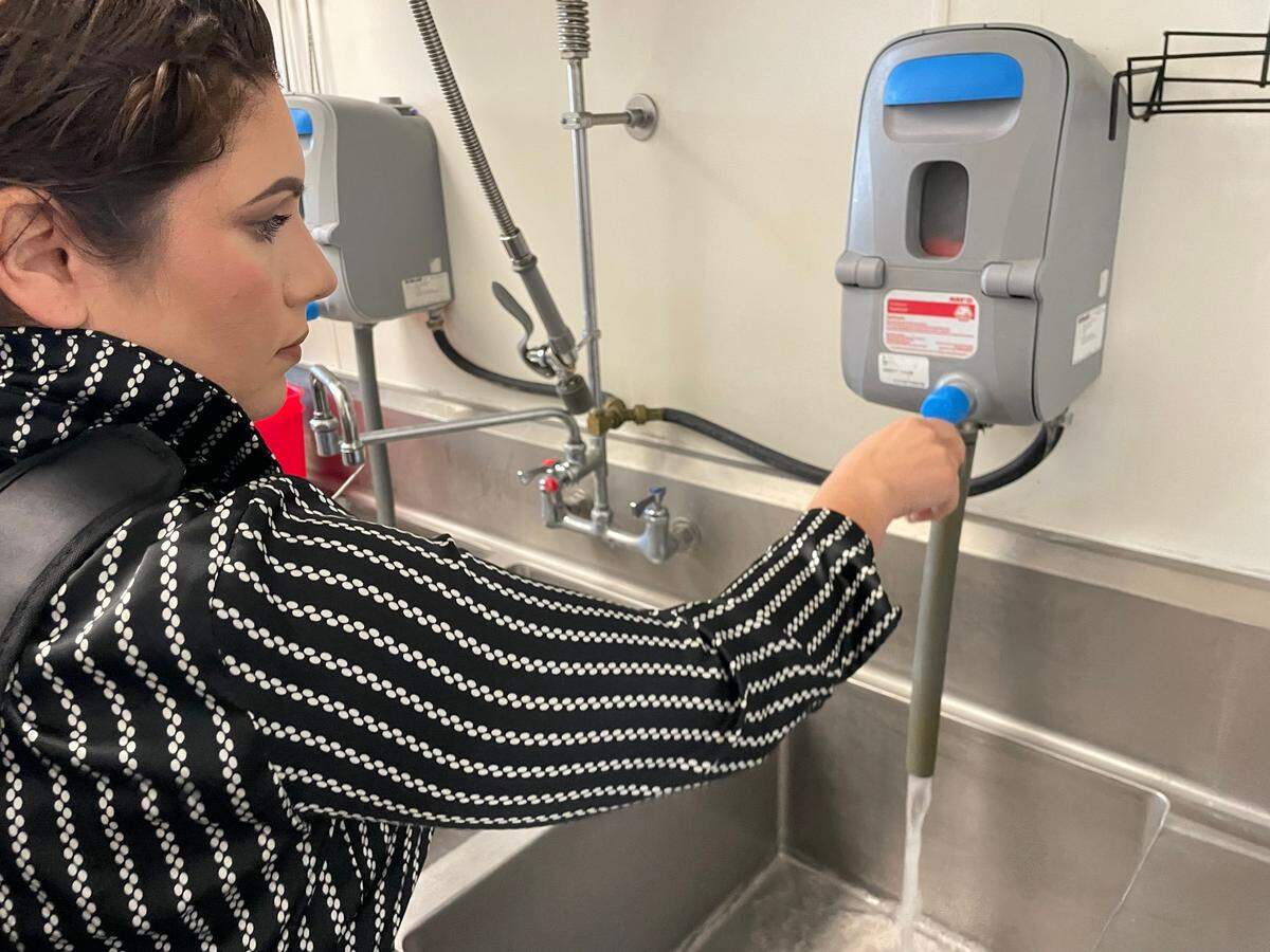 Registered Environmental Health Specialist Alondra Estrada checks the chemical levels of a sanitation device used for washing serving ware at The Tipping Point restaurant inside Save Mart on Sept. 5, 2024.