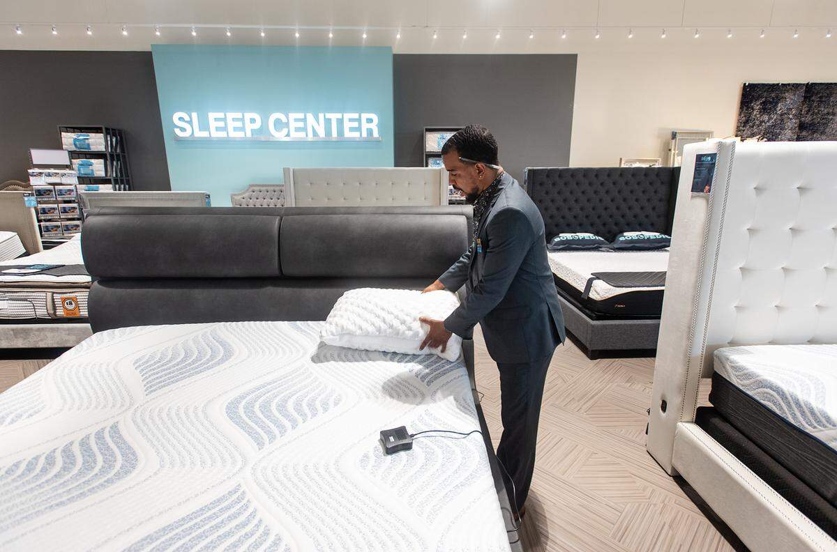 Assistant manager Brenden Reilly shows beds and pillows in the sleep center at Bob’s Furniture in Modesto Calif., on Friday, May 27, 2022.