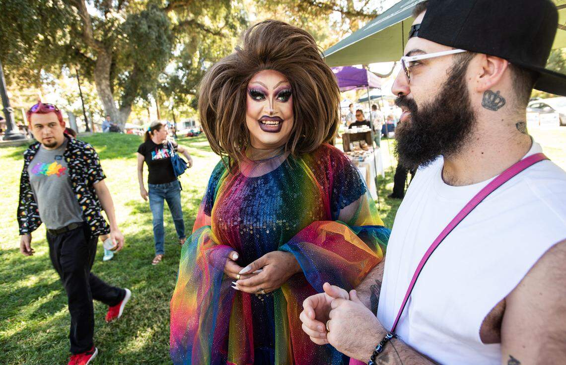MC Sasha Devaroe, middle, and her husband, Larry Soria, right, talk about their recent wedding during the MoPride festival at Graceada Park in Modesto, Calif., Saturday, Oct. 1, 2022.