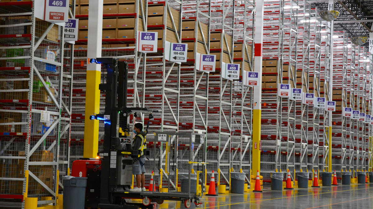 Un trabajador opera una carretilla elevadora entre filas de estantería de 40 pies de altura el jueves 20 de octubre de 2022, en el nuevo centro de distribución de Amazon que recientemente abrió en Turlock, California.
