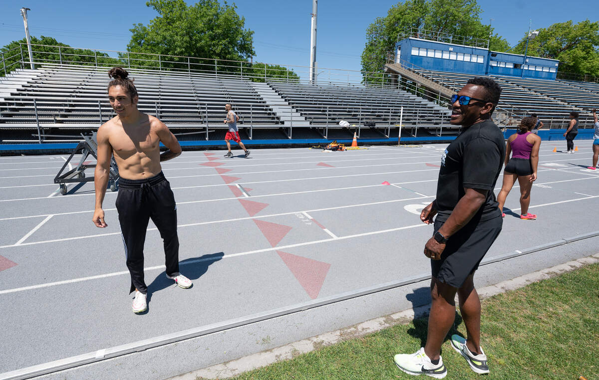 Coach Demitrius Snaer, right, talks with his team members including relay sprinter Kainoa Ontai, left, during practice at Modesto Junior College in Modesto, Calif., Tuesday, May 14, 2024.