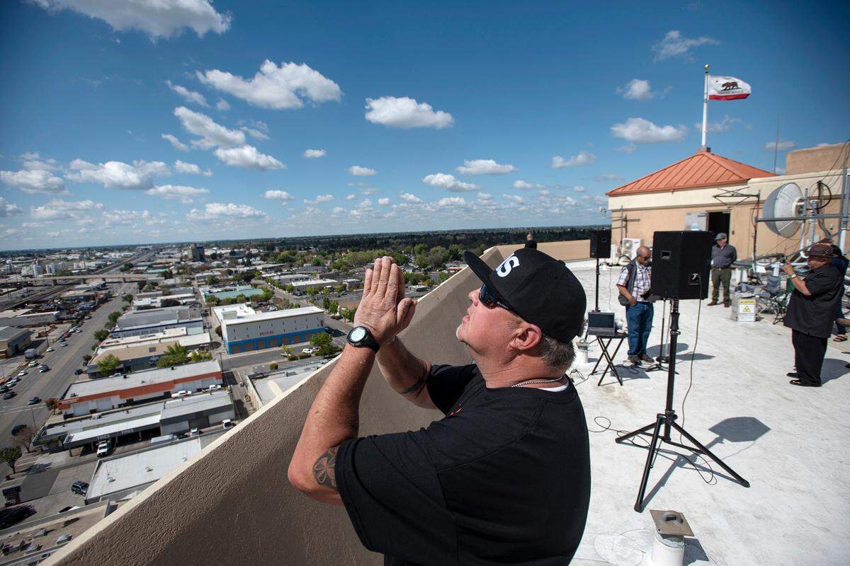 Justin Downs prays with other Modesto-area church members who gathered on the roof of the 15-story DoubleTree Hotel in Modesto, California, to pray over the city and for people affected by coronavirus in Modesto, Calif., on Tuesday, April 7, 2020.