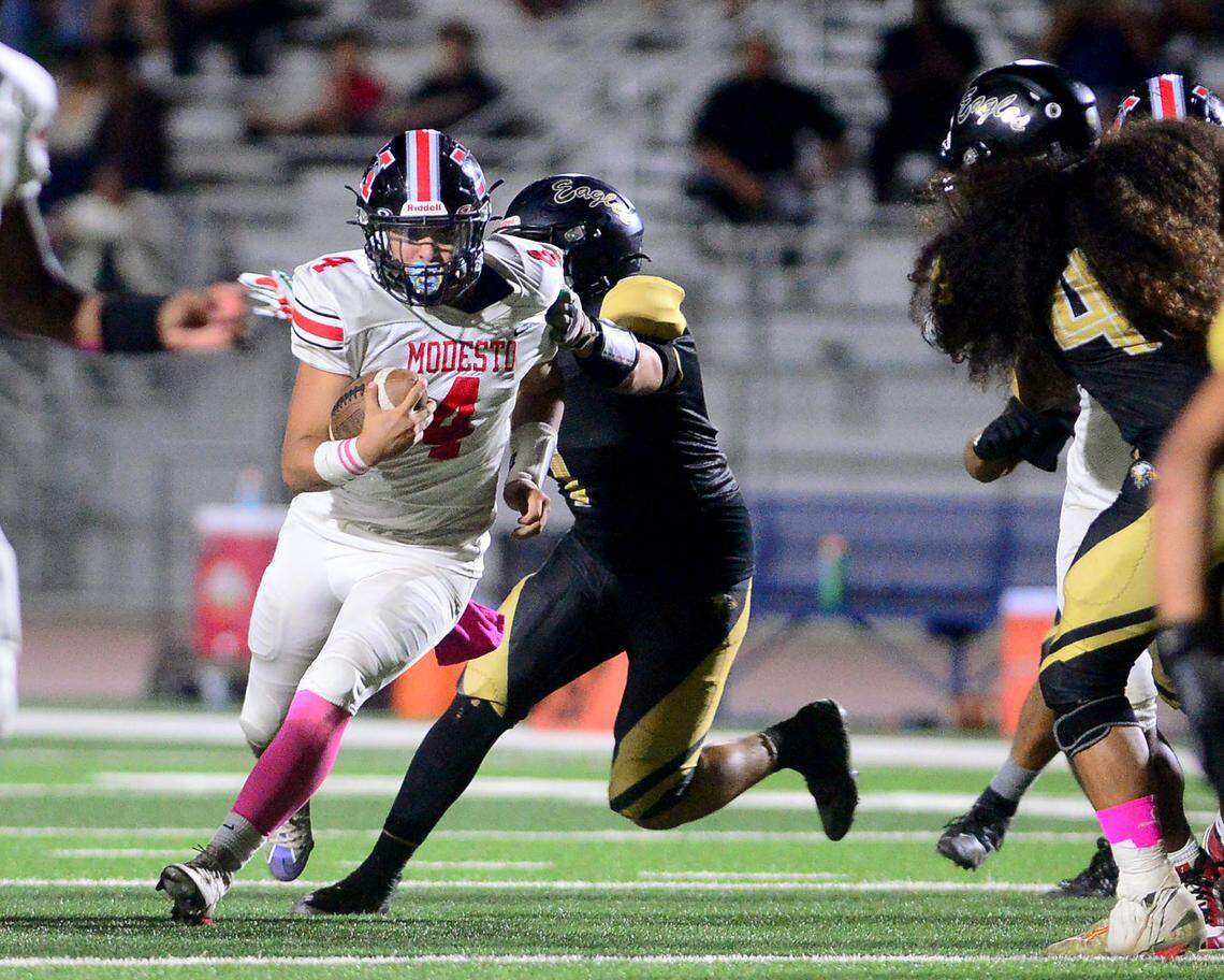 Modesto quarterback Israel Ceniceros (4) runs through an arm tackle during a game between Modesto High School and Enochs High School at Gregori High School in Modesto, CA on October 4, 2024.