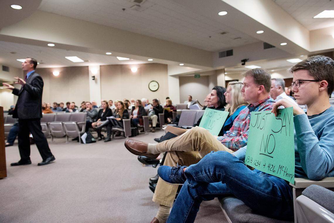 Mason Neumann, 15, right, holds a sign protesting the permitting of three cannabis retailers on McHenry Avenue during a special Modesto City Council meeting on cannabis dispensary permitting at Tenth Street Place in Modesto, Calif., Wednesday, Dec. 19, 2018.