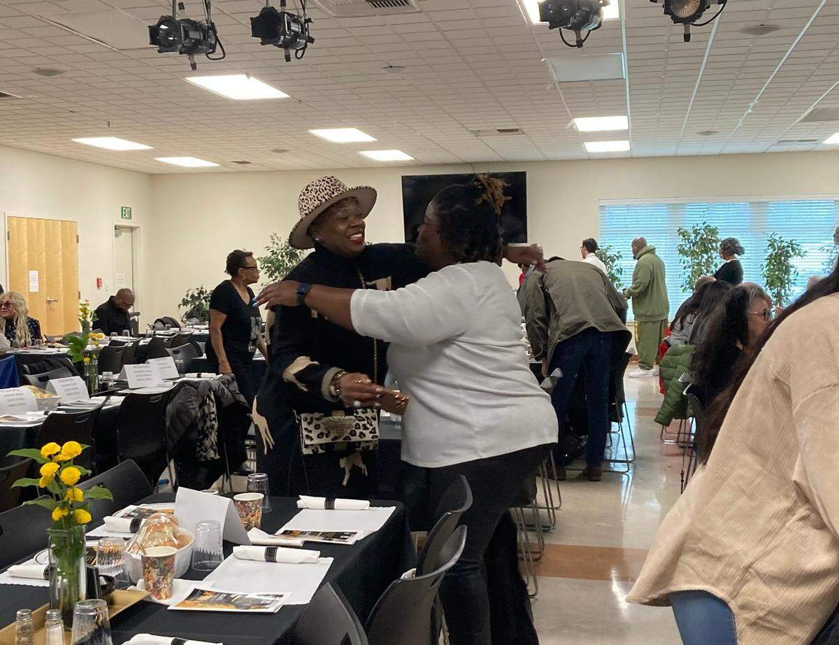 Gia Smith (left), a mental health nurse who works with Legacy Alliance Outreach, and Latricia Beasley-Day, community organizer with Faith In The Valley (right), embrace at the King-Kennedy Memorial Center’s annual MLK Celebration Luncheon on Jan. 13, 2023.