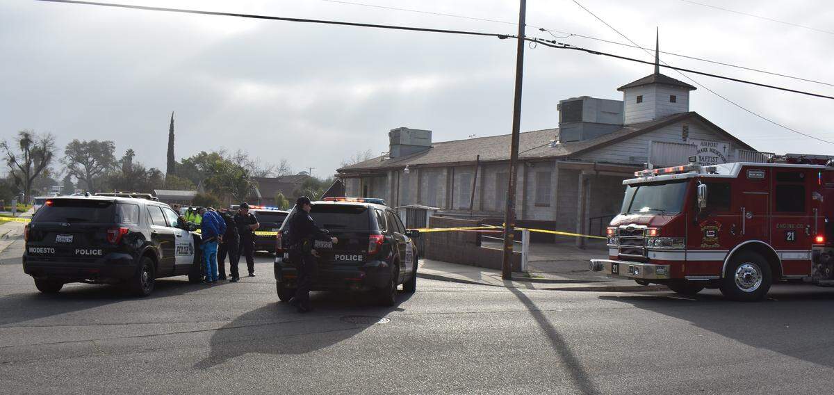 Modesto police take a man into custody at the scene of a fatal double shooting on Thrasher Avenue in the airport neighborhood on Tuesday afternoon, Dec. 21, 2021.