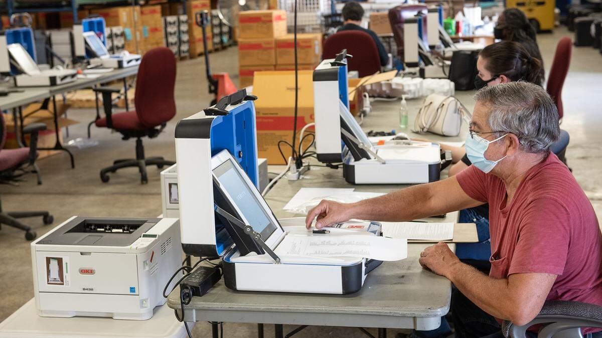 Registrar of Voters part-time staff member Alan Autrand tests a ballot machine in the county elections warehouse in Modesto, Calif., on Thursday Oct. 2 2020.
